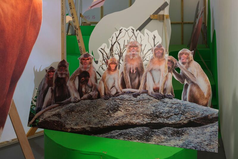 From Heather Phillipson's exhibition. A cut-out photograph of a group of monkeys sitting on a log.