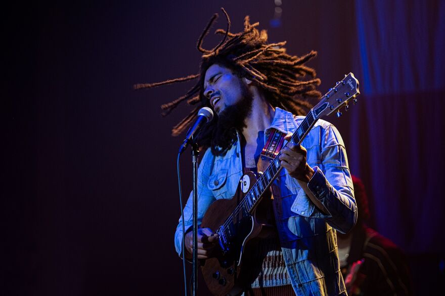 Kingsley Ben-Adir as Bob Marley, singing and playing guitar.