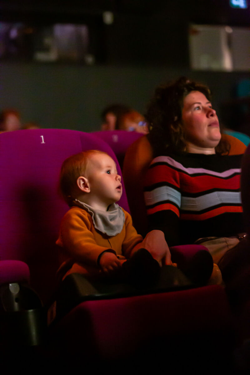 Child and parent sitting in cinema seats