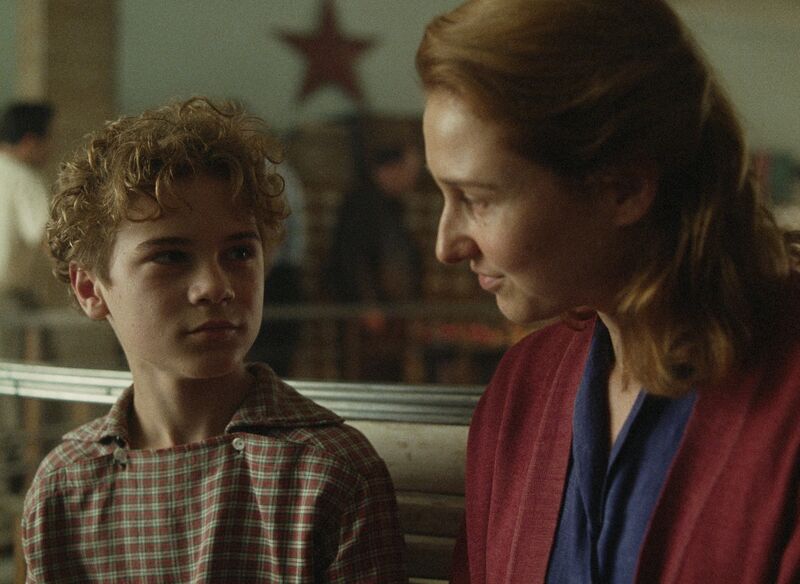 A mother and tween son look at one another.