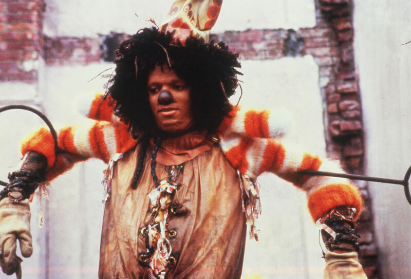 A young black man in a scarecrow outfit