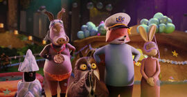 A group of animated anthropomorphic creatures stand together - a penguin, warthog, owl, fox and rabbit.