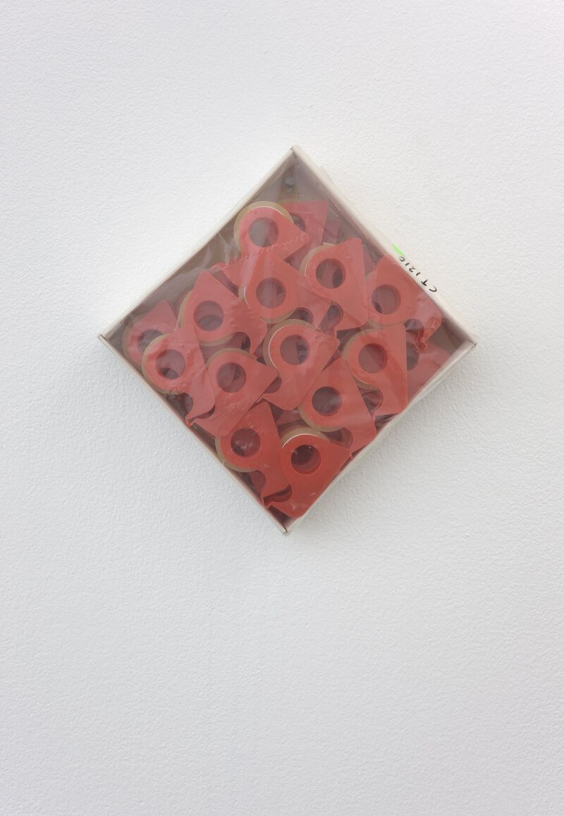 From Sara MacKillop's exhibition. Rolls of red, plastic tape dispensers are sealed in a wooden box and hung on the wall.