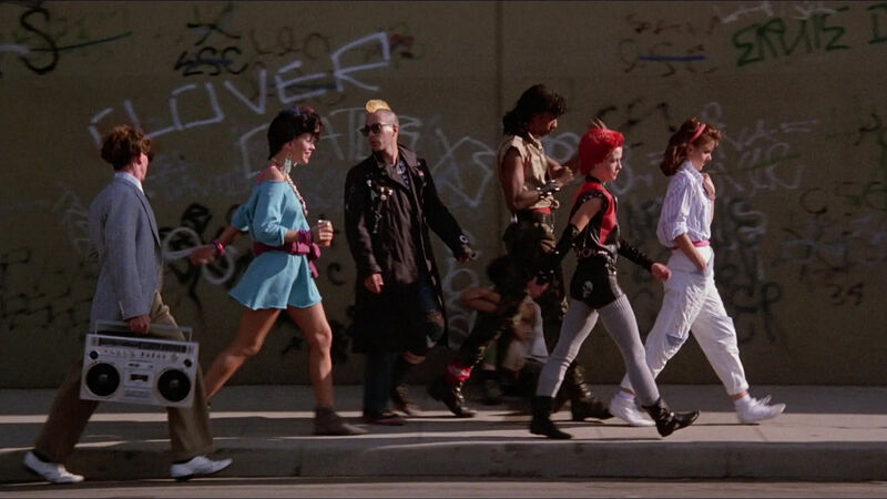 Group of people walking down the street dressed in 80s outfits