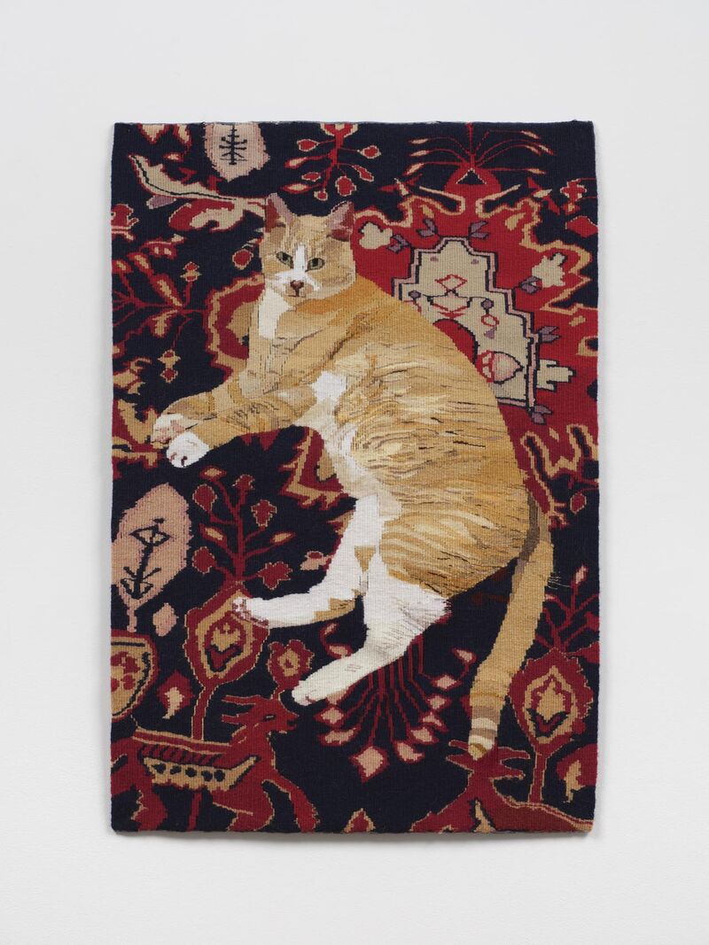 A tapestry of a ginger cat lying on patterned Persian rug