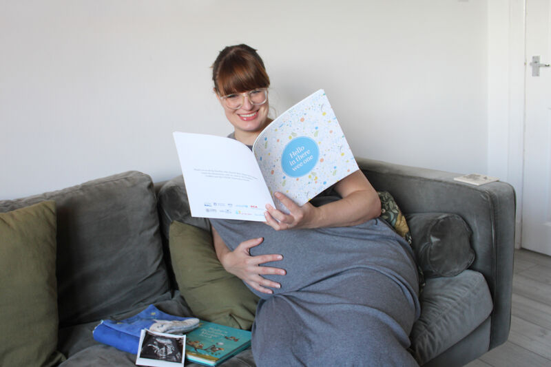 Pregnant person reading Hello in there wee one