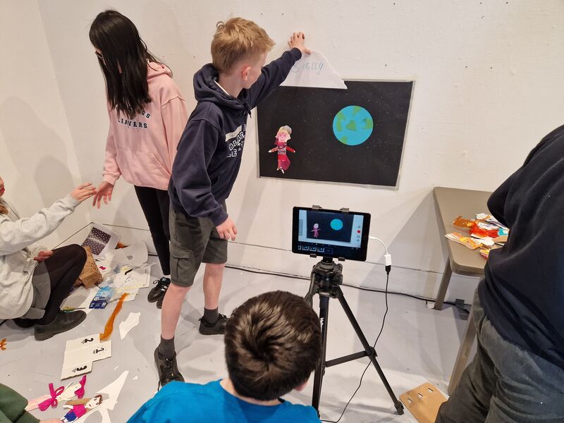 School pupils making an animation using paper