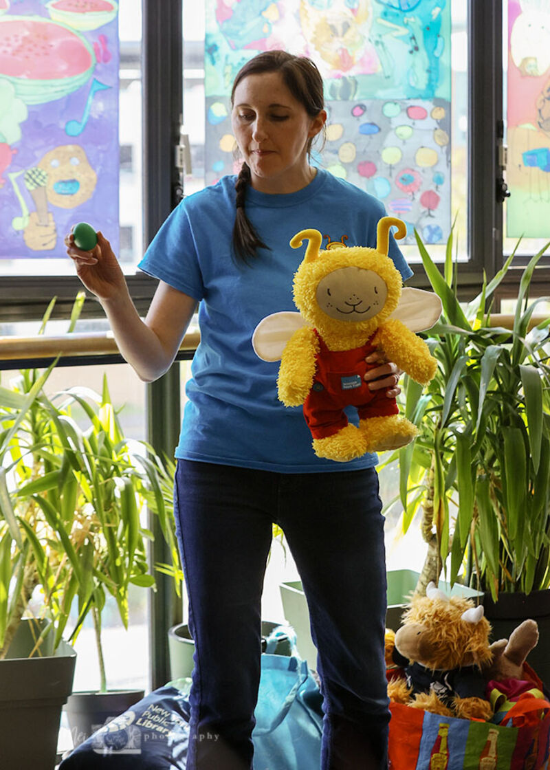 Book Bug storyteller telling a story while holding a Book Bug cuddly toy