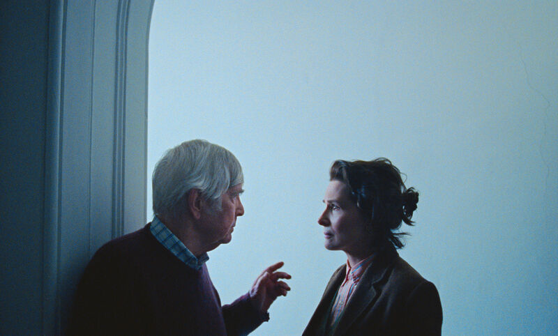 An old man reaches out to a woman who stands across from him