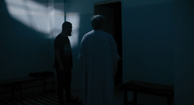 Two people standing in a dark room