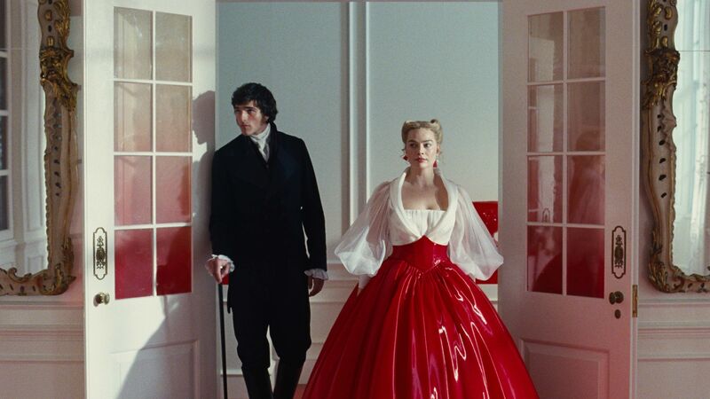 A man in a suit and a woman in a billowing PVC dress walk into a room