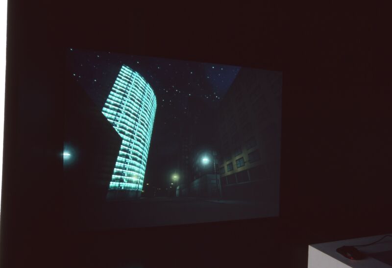 A projector shows an image of a modern building covered in blue lights, sitting on an empty street at night.