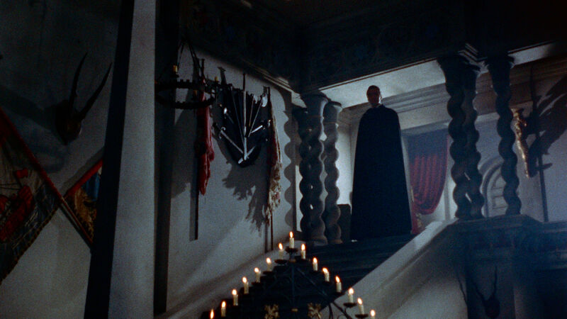 Caped figure at the top of the stairs
