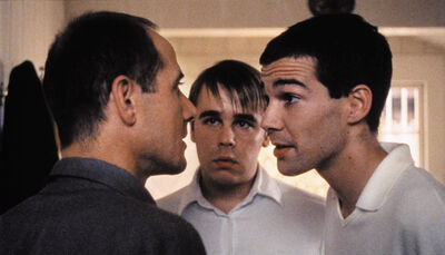 Two men argue with one another, while another man looks on