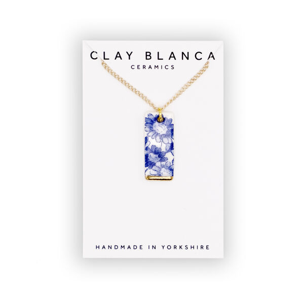 Clay Blanca Ceramics blue rectangular pendant made of blue floral patterned china on a gold chain