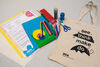Family Art Bag tote bag on a table beside contents of art making materials and activity sheets