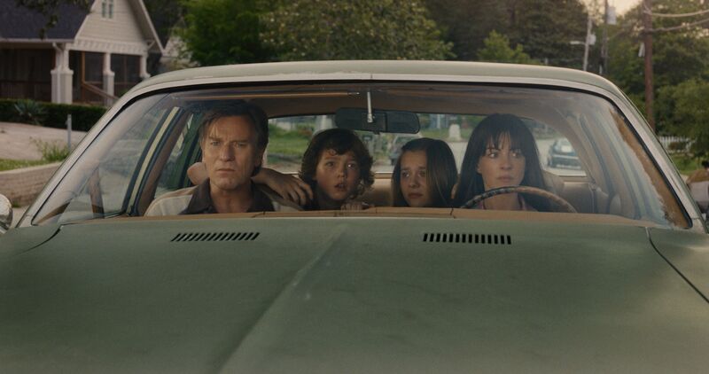 A family in a car, looking scared