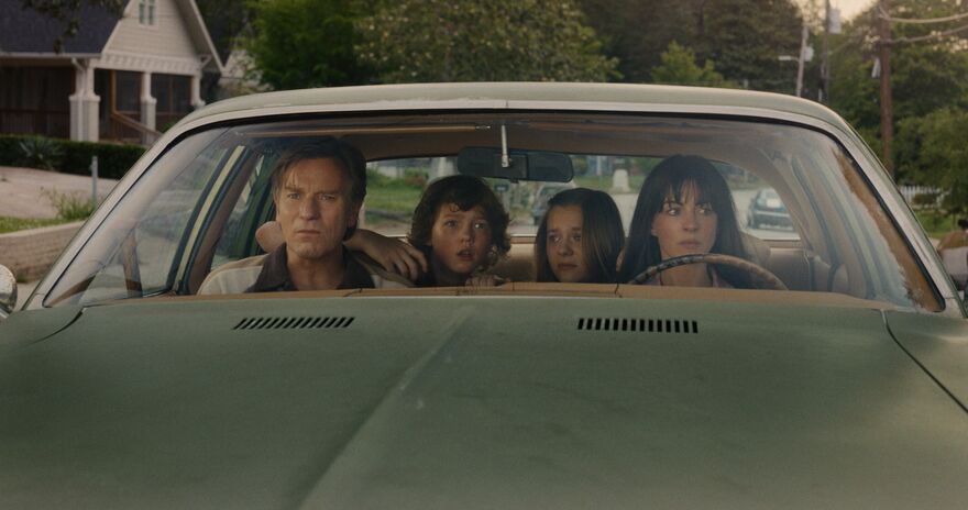 A family in a car, looking scared