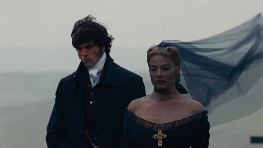 A man and a woman wearing 1800s funeral attire stand on a misty moor.