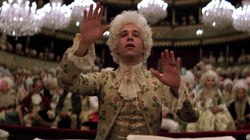 Mozart directs the orchestra in a grand concert hall.