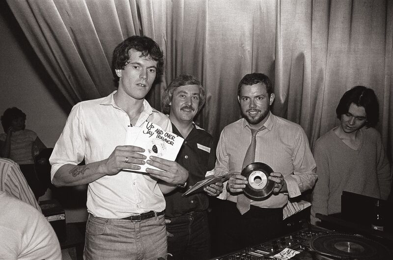 Three men holding vinyl records.
