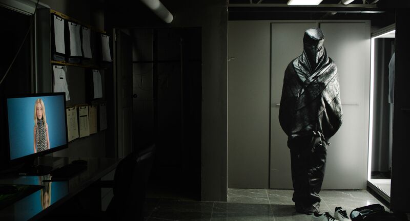 A black body bag stands upright in a closet.