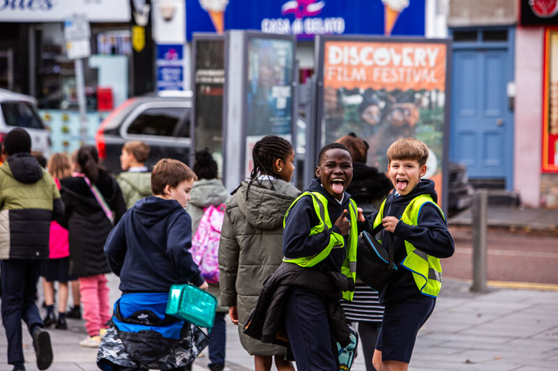 Two school boys stick out their tongues and smile as they leave DCA