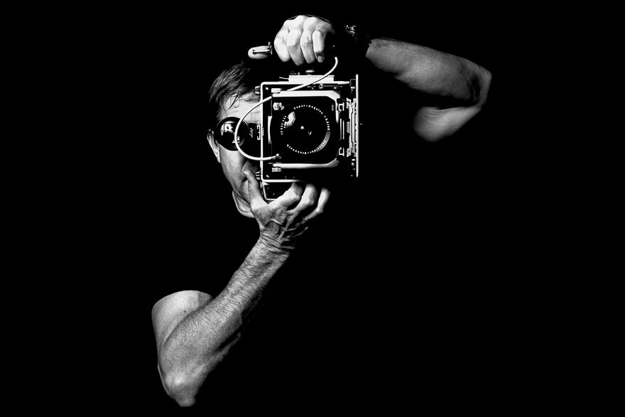 Black and white photograph of Alan Hillyer holding a camera 