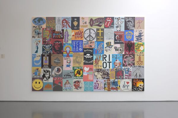 A large mural from There Will Be New Rules Next Week exhibition at DCA shows a collection of recognisable iconography, including a cross, a peace symbol, Che Guevara, a smiley face, and the I Heart NY sign.