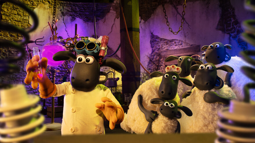 A group of claymation sheep in a lab. One holds up a test tube while the others cower in fear