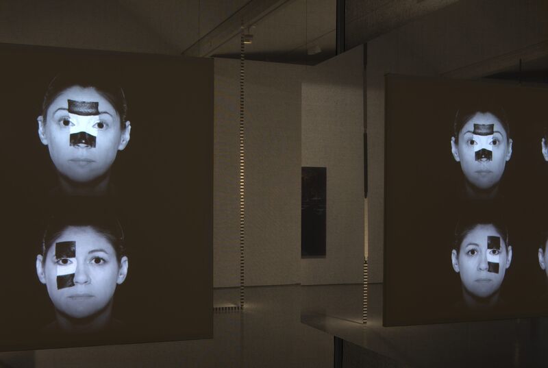 From Jane & Louise Wilson's exhibition. 4 photographs on the wall of two people's face. They both have white-and-black rectangular faceprint over their eyes and noses.