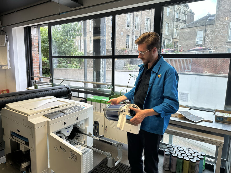 Luke Greer in DCA Print Studio loading up the Risograph Machine with ink