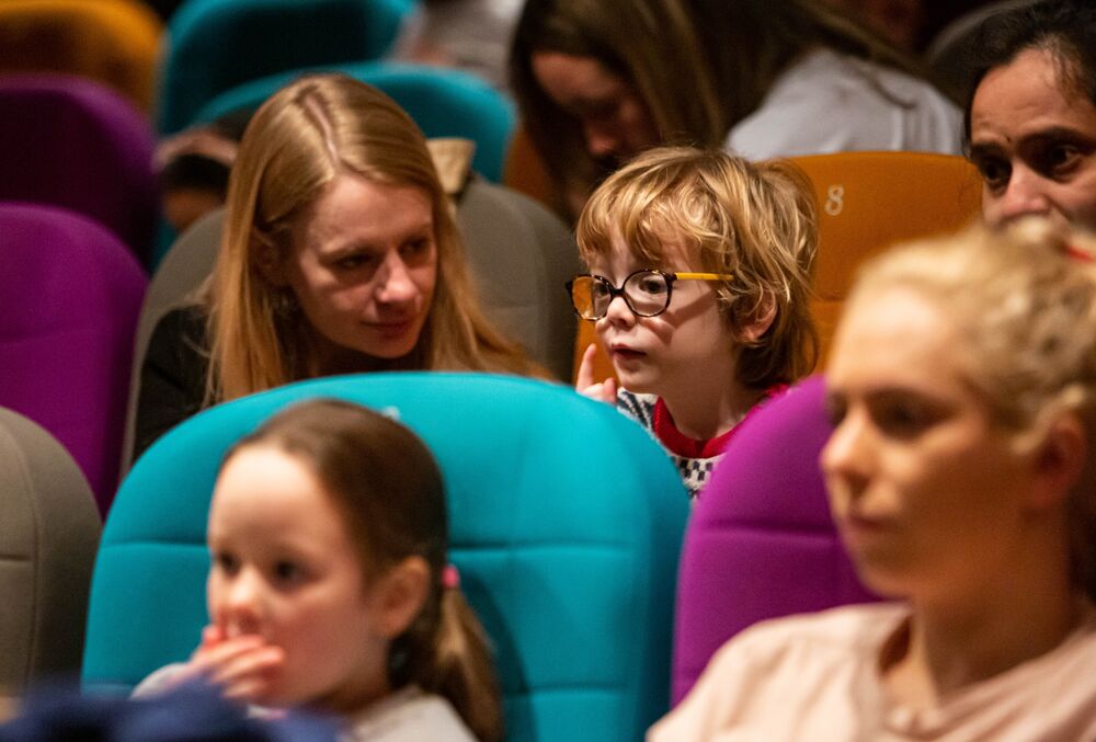 Children and their carers sit in DCA Cinema to watch a film