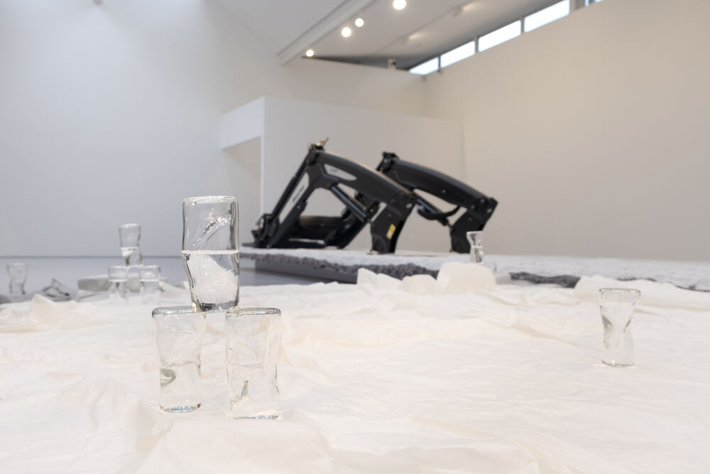 Glass sculptures on paper with farm machinery in the background