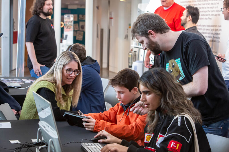 Developer showing a child how to play their game at Drop in and play