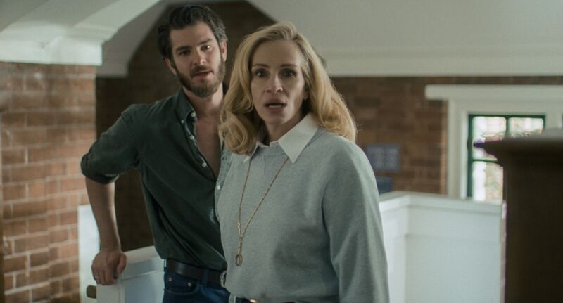 A woman looks shocked, while a man stands behind her looking surprised.