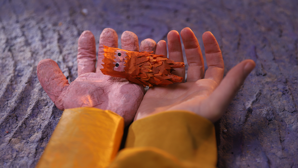 A little character rests in the hands of a boy in a cute animated still