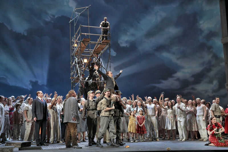 A crowd lift a cheering cast member onto their shoulders in Fidelio