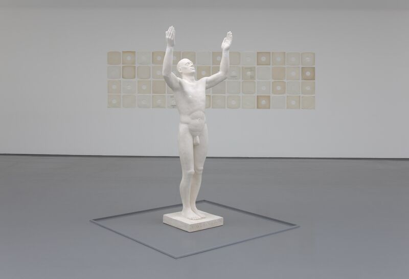 From Ruth Ewan's exhibition. A white statue of a naked person throwing their hands up in the air.