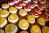 Cupcakes topped with Discovery smiliy face logo in yellow and red