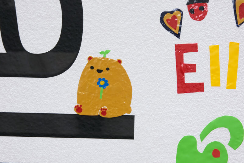 Vinyl artwork of a cartoon bear holding a flower