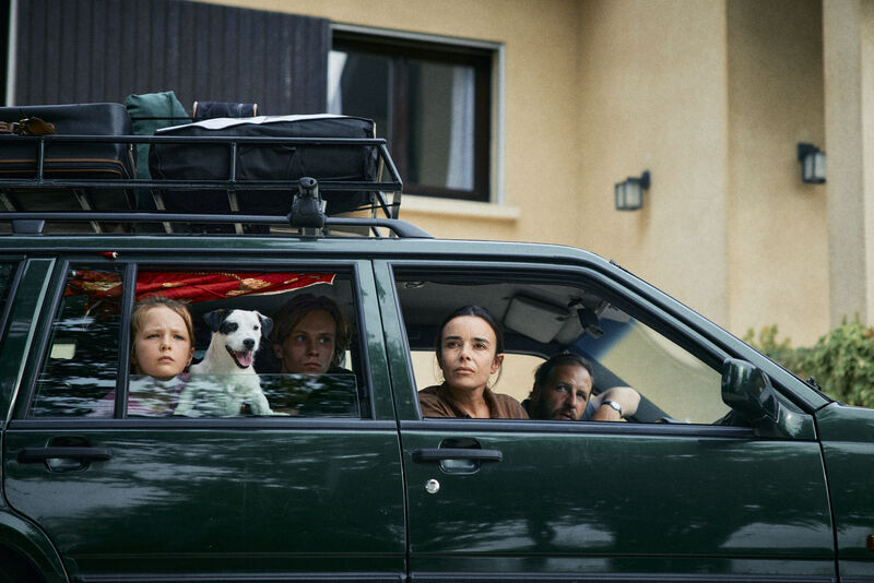 Family in a car with luggage strapped to the roof
