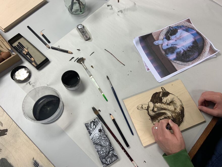 Person working on a mokulito print of a cat