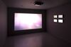 From Hiraki Sawa's exhibition. A screen shows a warm, pale pink light.