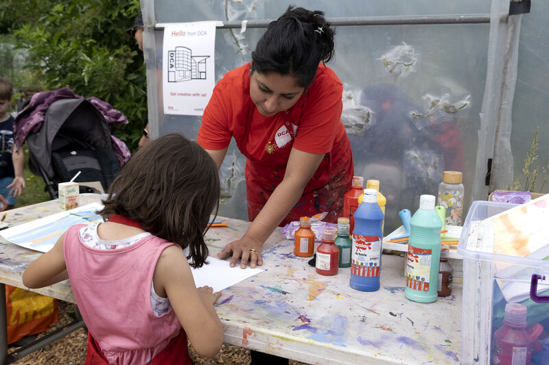 DCA artist tutor helping a child to create squegee prints