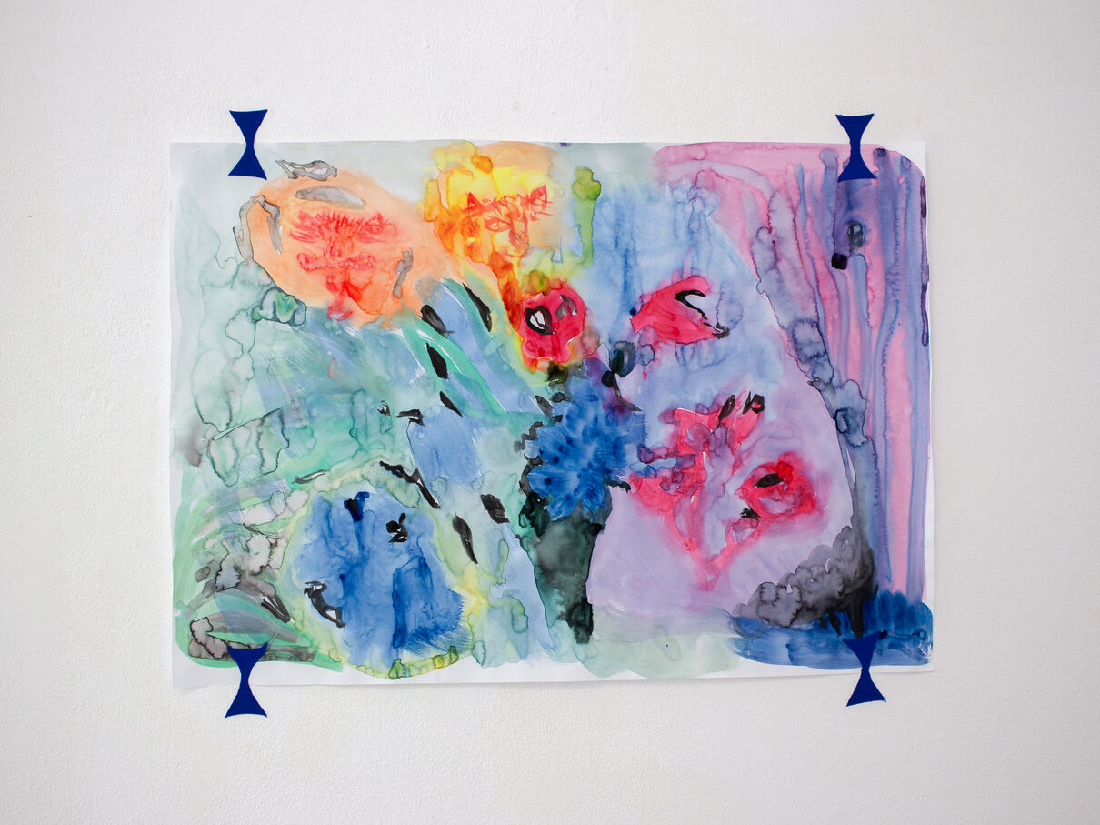 A multicoloured painting hung on a white wall. colours bleed into each other in the painting