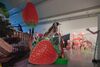 From Heather Phillipson's exhibition. A large cut-out photograph of a finch sits on top of some equally large cut-out photographs of strawberries. In the background, statues of flamingos and giraffes can be seen.