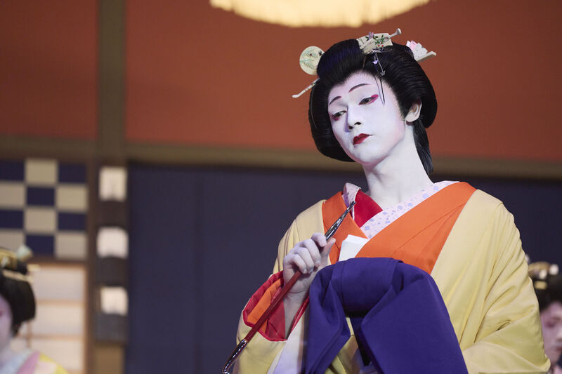 A woman on stage in geisha makeup