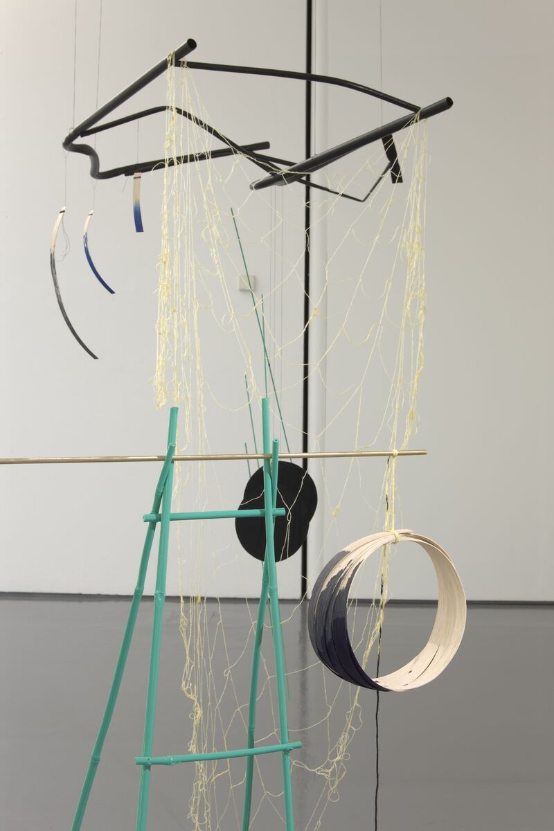 A sculpture from Mary Redmond's exhibition. A mobile is made up of netting and wooden shapes.