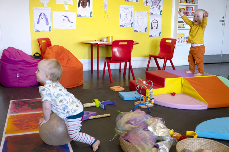 Two toddlers enjoy a play area